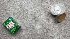 overhead shot of grey carpet with baking soda to demonstrate how to clean carpet with baking soda