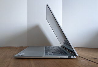 A silver Dell Inspiron 7620 2-in-1 laptop sitting on a wooden desk