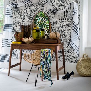room with wooden table and palm print backdrop