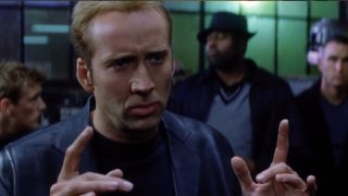 Nic Cage, fingers at the ready, dressed in a fly black suit and surrounded by his browskies, is about to get his cage on in Gone in 60 Seconds.