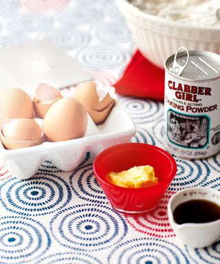 eggs, butter and baking powder on patterned table cloth
