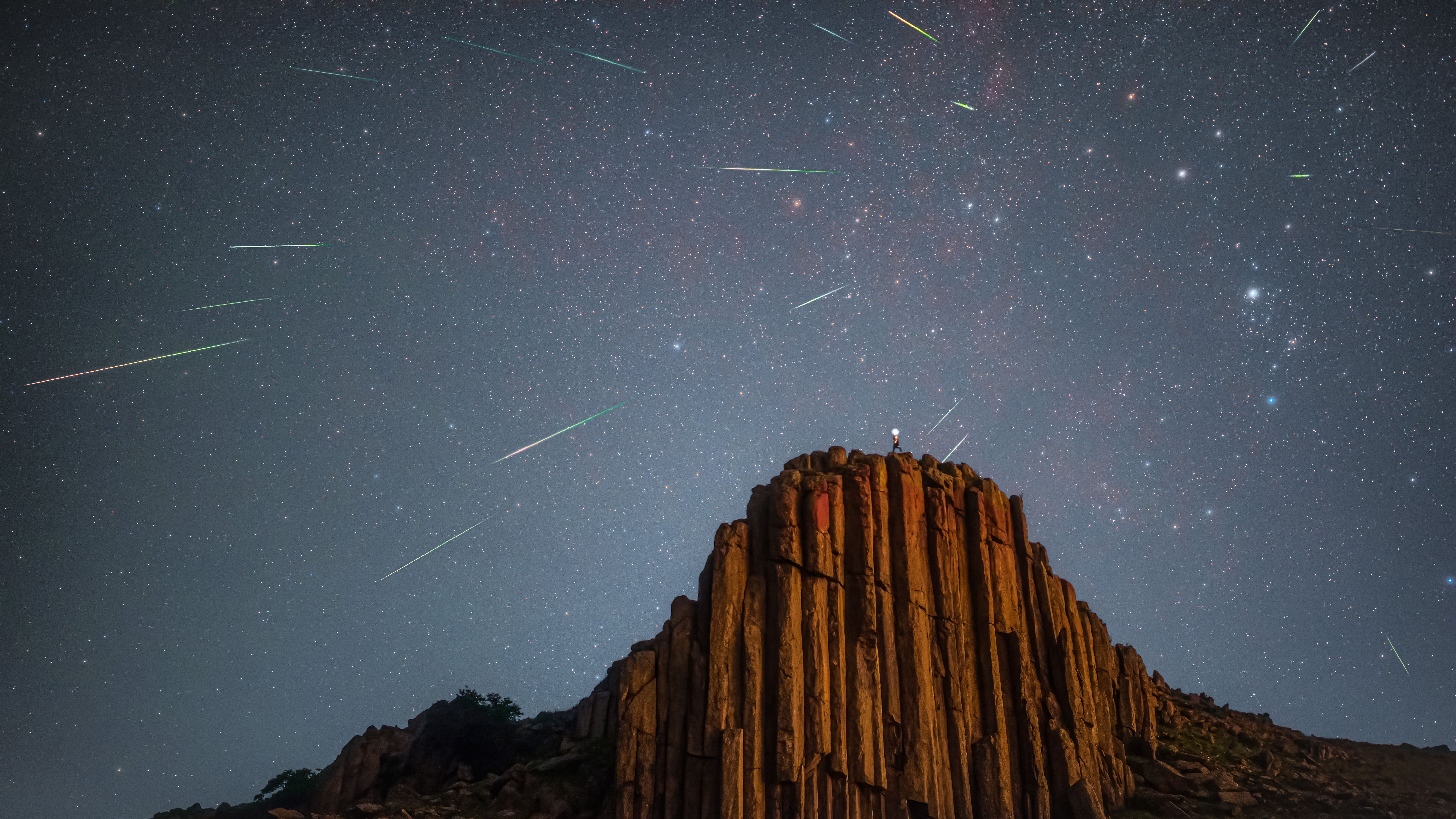 On August 13, 2021, it was shot in Baochang County, Inner Mongolia, China. It was only a few kilometers away from Baochang County, so the light damage was very serious. By midnight, half of the lights in the city were turned off, and the effect was better. Nikon D810 changed the machine and Sima 40art. Finally, I took a portrait at the top of the mountain with the light."nShitiao mountain, located in Taipusi Banner, Inner Mongolia, is one of the seven major volcanic rock columns in China. The stone column is a basalt rock column formed by the condensation of volcanic magma. Shitiao mountain was formed about 230 million years ago. At the bottom of the ocean, because of the high latitude, the sea is water-cooled, and the lava erupted by the volcano is rapidly cooled by the sea, forming columnar joints.