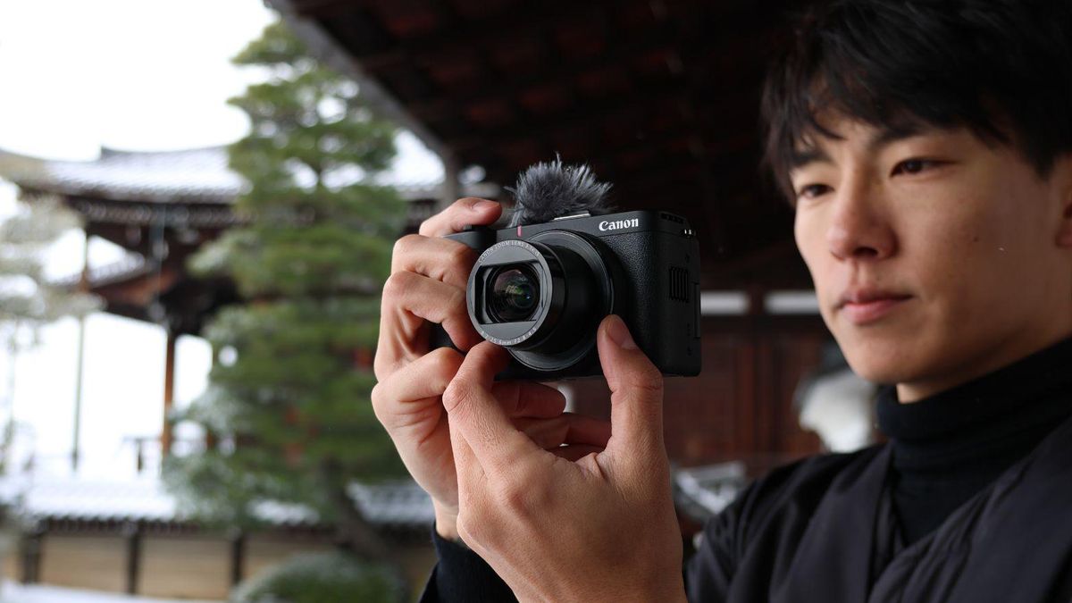 Canon PowerShot V1 in user&#039;s hands, oudoors with a snowy Japan backdrop