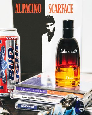 A can of Bud Light beer and bottle of Fahrenheit by Dior on top of CDs