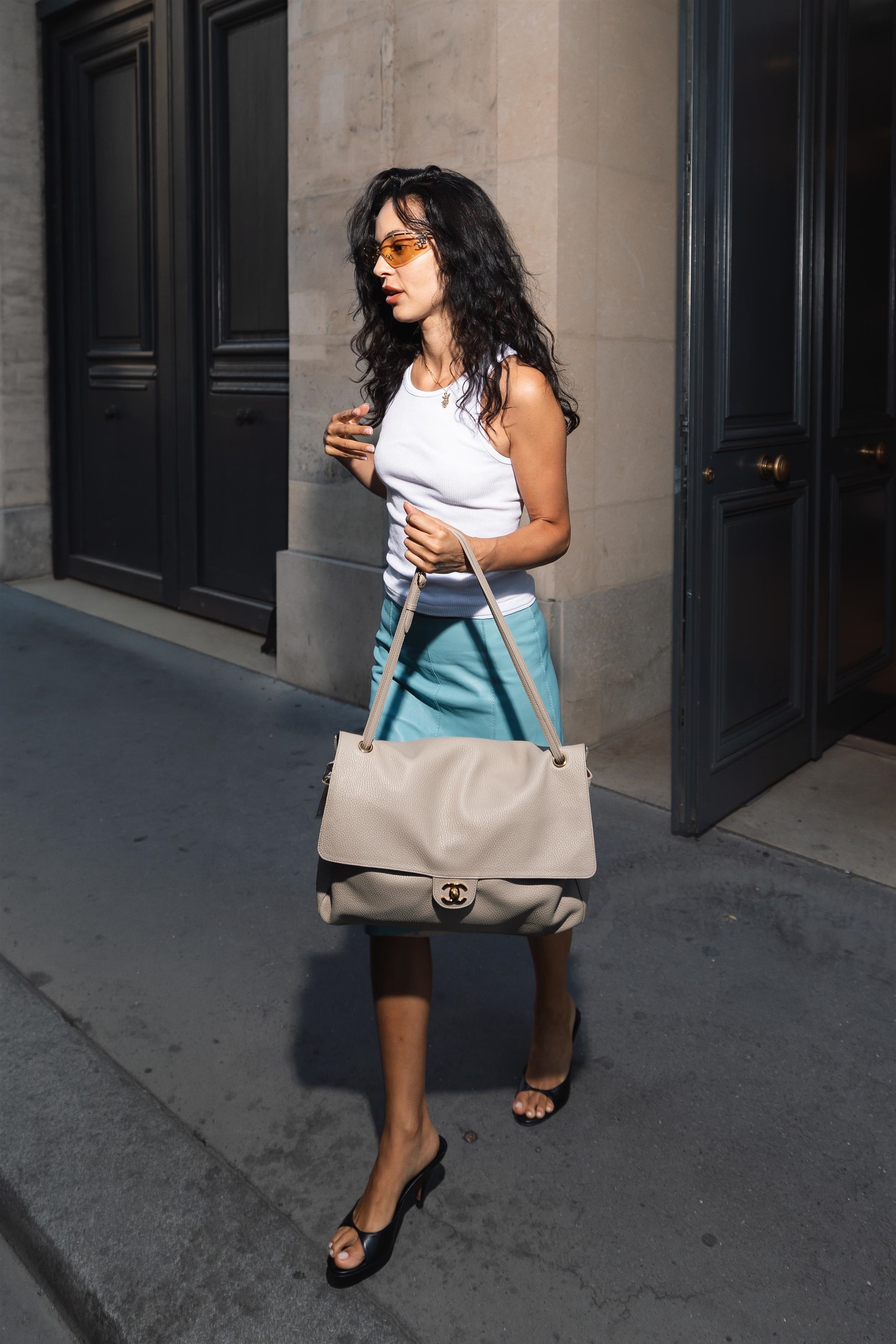 Alexa Demie wears a white tank, blue knee skirt, and peep toe wedges summer fashion trends 2026