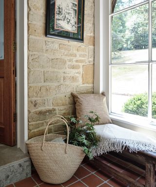 porch of country home with wooden bench and basket on floor