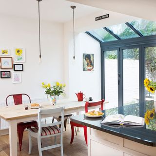 an open plan kitchen diner with large bifold windows and rooflights