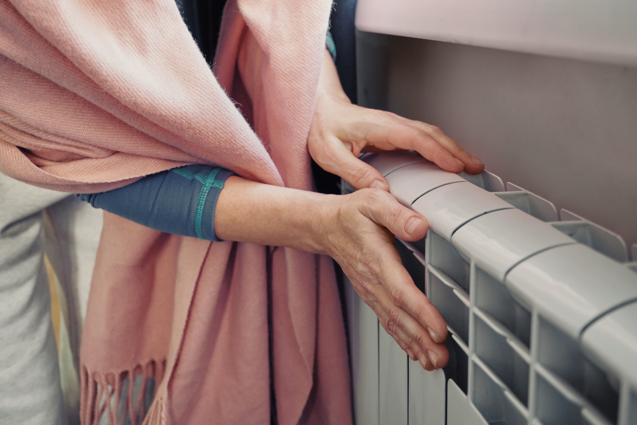 Woman feeling warmth from radiator