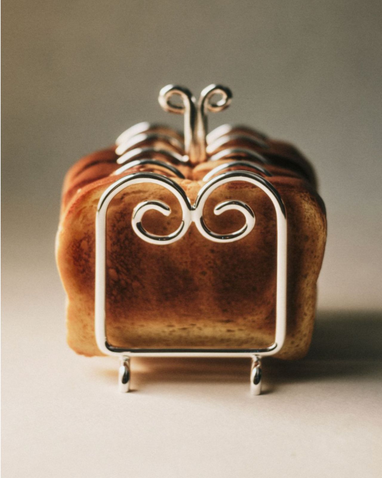 Silver toast holder with toast in it.