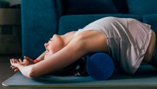 Woman using a foam roller to stretch her back