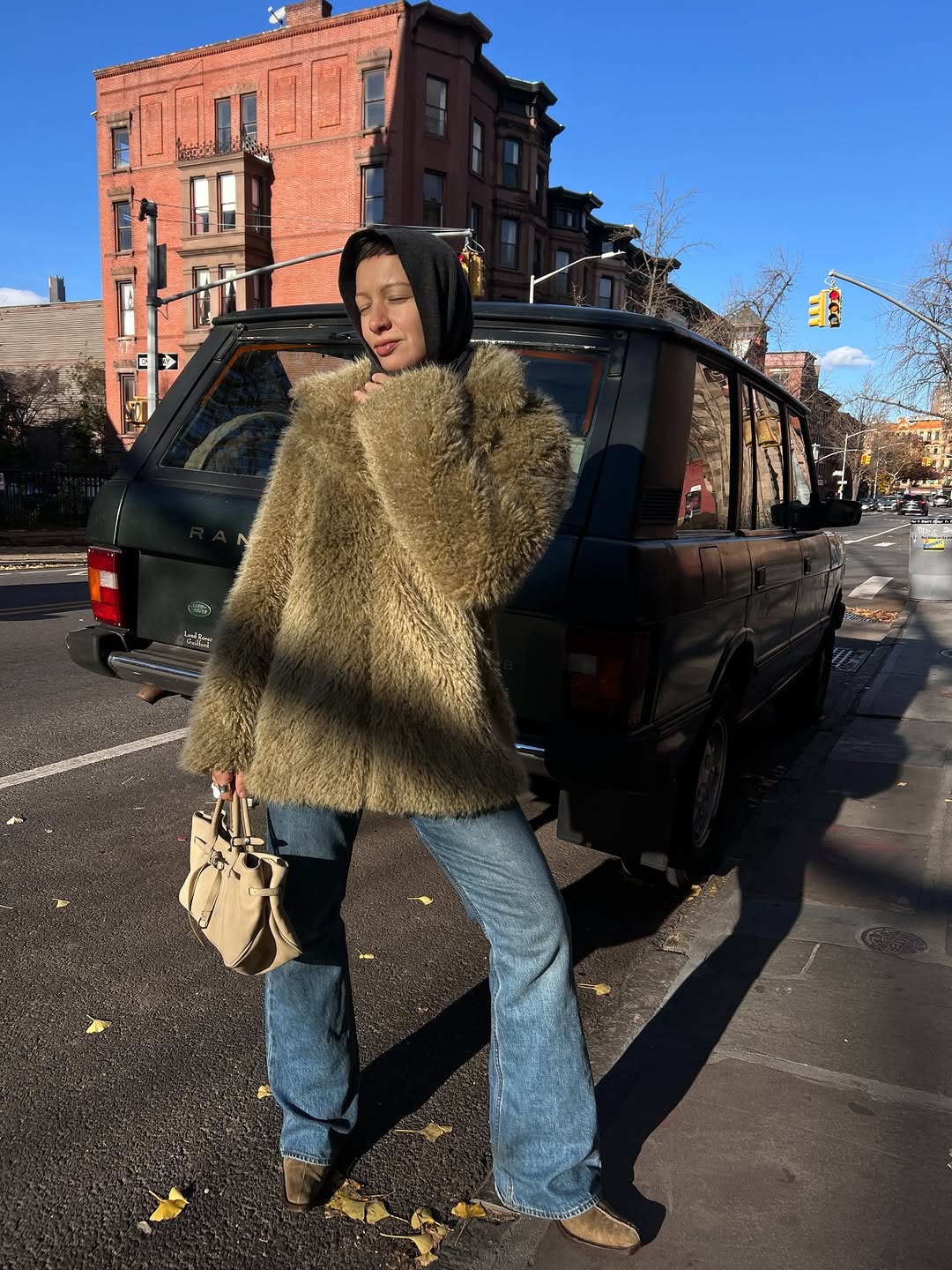 Woman wearing bootcut jeans with light suede ankle boots.