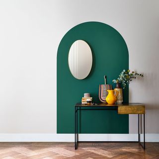green door shape designed on white wall flower pot on desk and wooden flooring