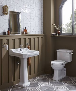 olive green and grey bathroom with white traditional pedestal sink and white toilet