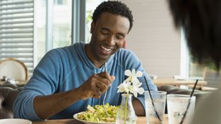 Man smiling and eating a healthy meal