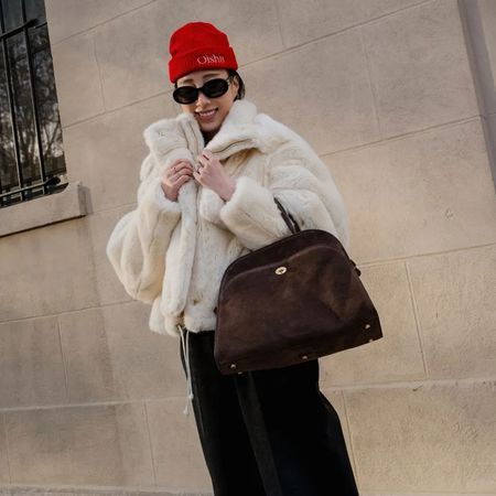 a woman wears a red beanie with a white jacket