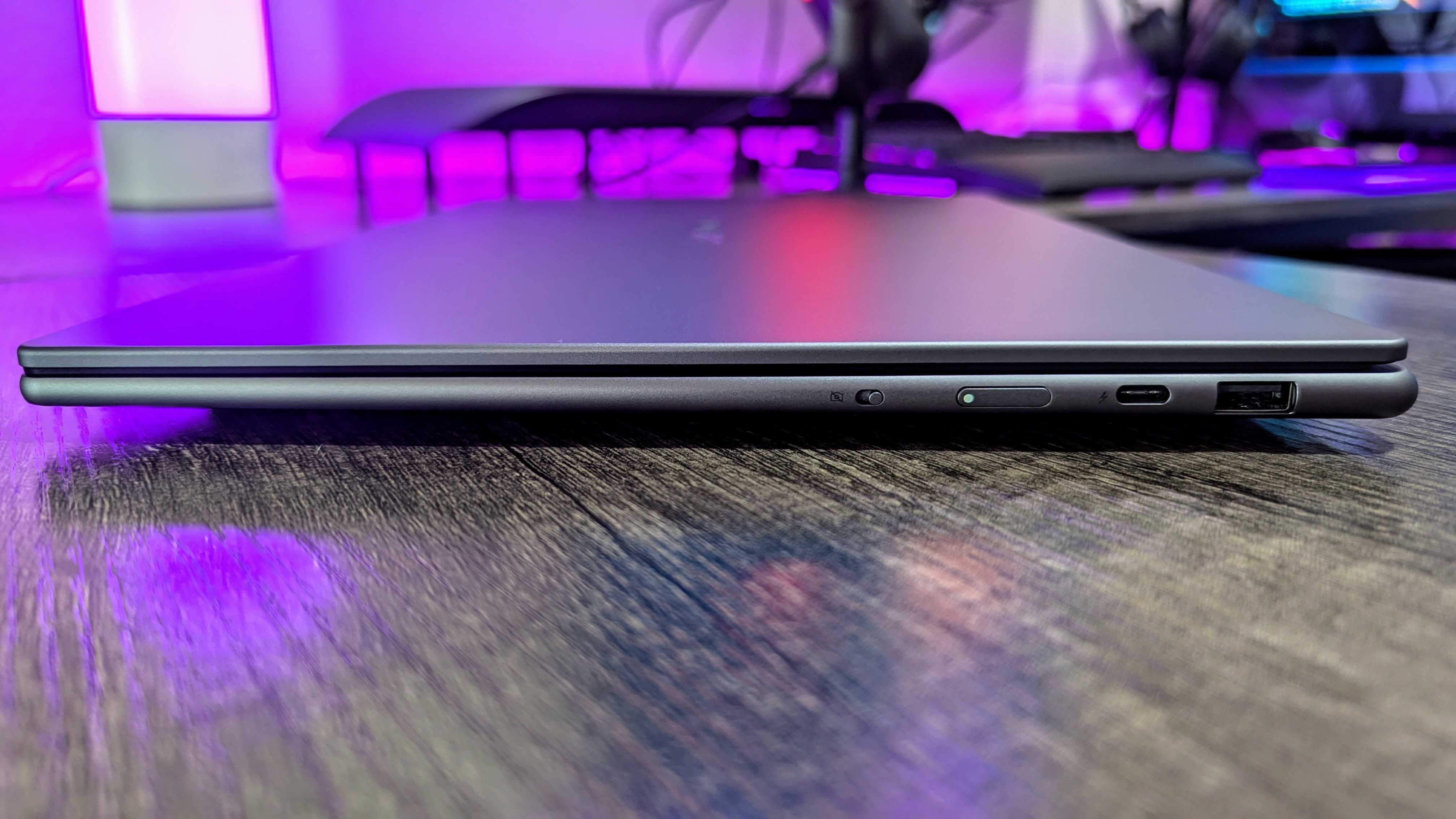 The Lenovo Yoga Slim 7i (Gen 9) Aura Edition from the side, showing the USB Type-A and Thunderbolt 4 ports, the power button, and the electronic privacy shutter.