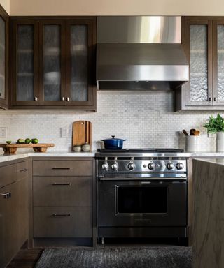 Dark wooden kitchen with marble tiled backsplash