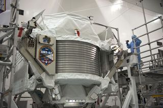 Technicians examine the $2 billion Alpha Magnetic Spectrometer instrument in a work stand ahead of its planned launch on NASA's space shuttle Endeavour. The AMS instrument will search for cosmic rays from the International Space Station. 
