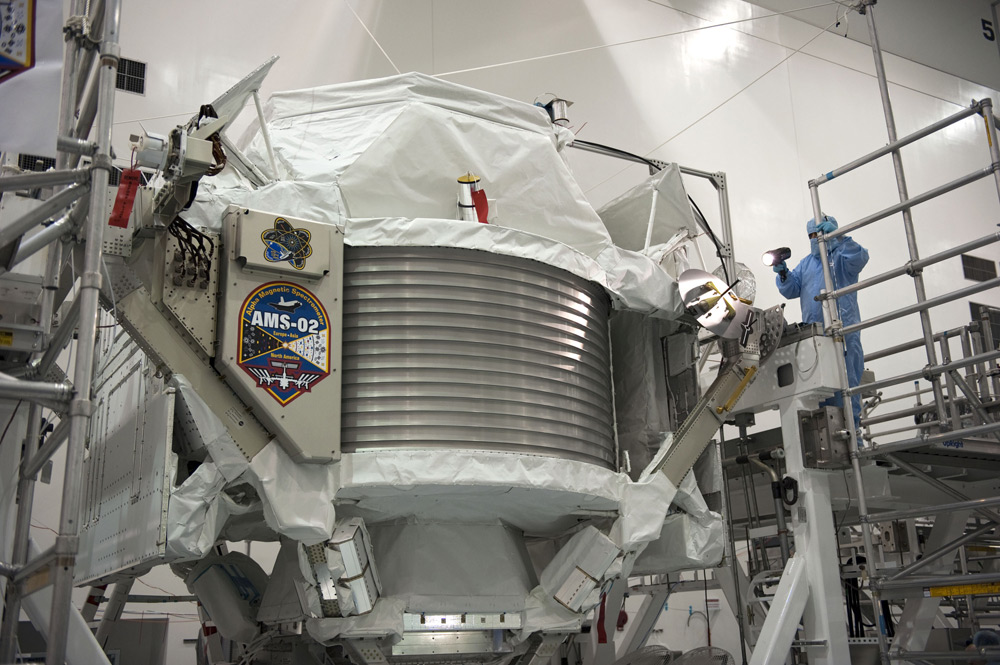 Technicians examine the $2 billion Alpha Magnetic Spectrometer instrument in a work stand ahead of its planned launch on NASA&#039;s space shuttle Endeavour. The AMS instrument will search for cosmic rays from the International Space Station. 