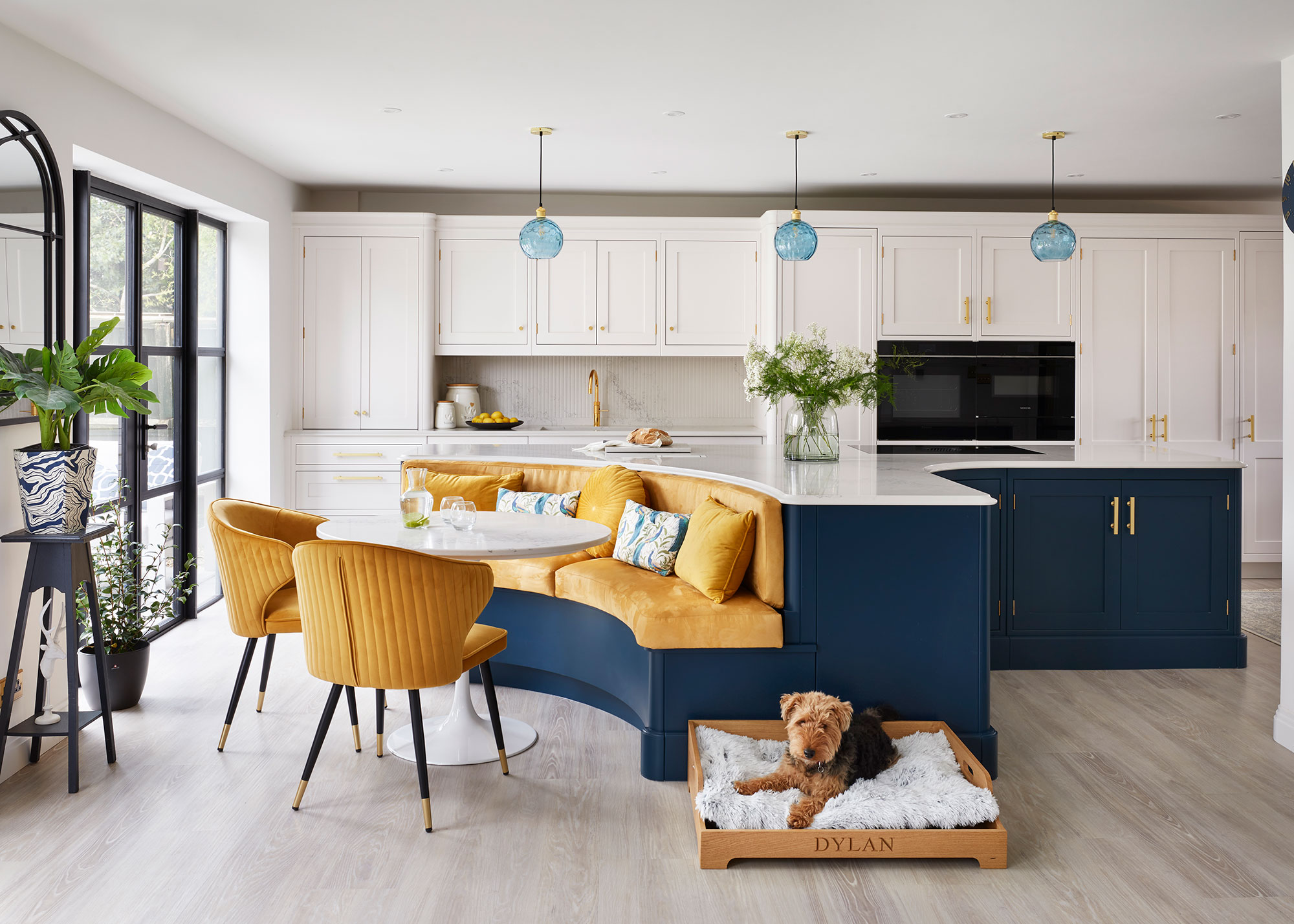 blue curved kitchen island with yellow banquette seating