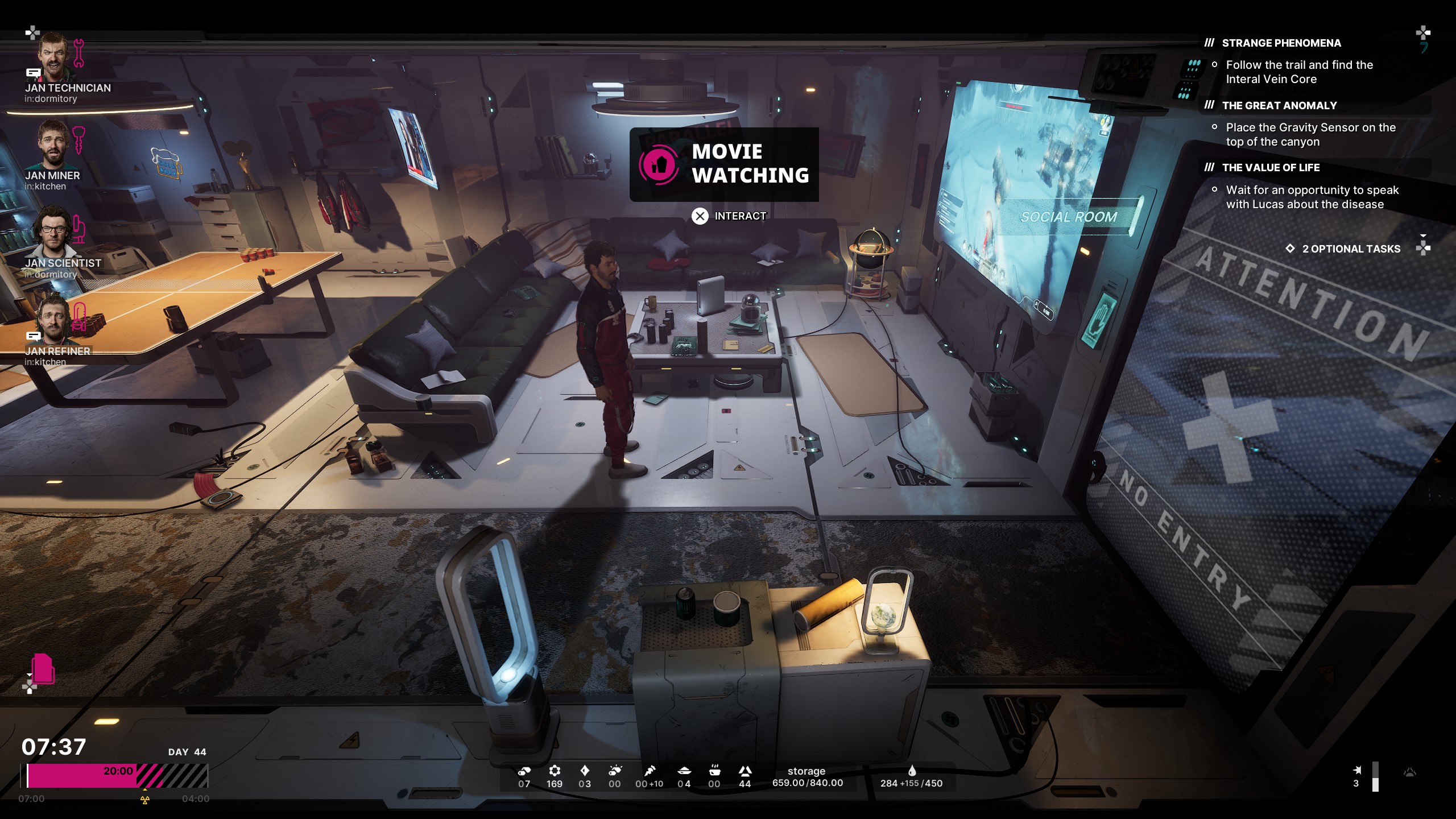 The Alters gameplay screenshot showing protagonist Jan standing in the social room about to watch a movie