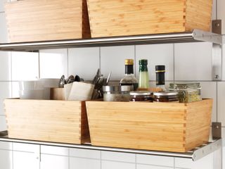 kitchen with metal shelving and wooden storage boxes with spices, oils, cutlery, white square wall tiles