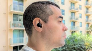 Side profile of Tom's Guide reviewer Alex Bracetti wearing Sony's WH-C700N ANC earbuds