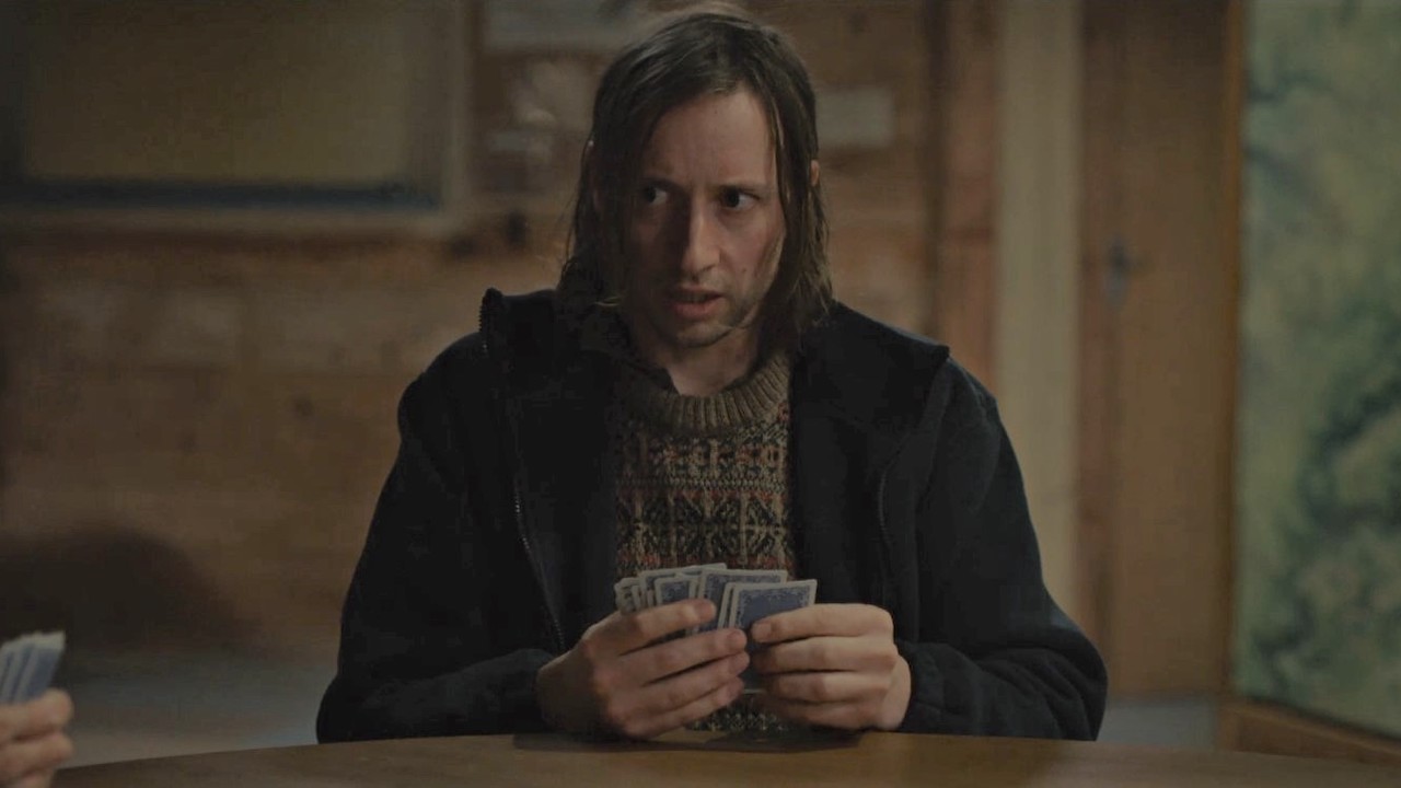 David Rysdahl holding cards in Hulu's No Exit