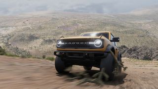 A screenshot from Forza Horizon 5 showing a Ford Bronco truck climbing a hill towards the camera