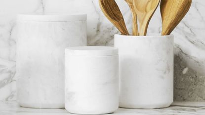 three marble coffee canisters on a marble countertop
