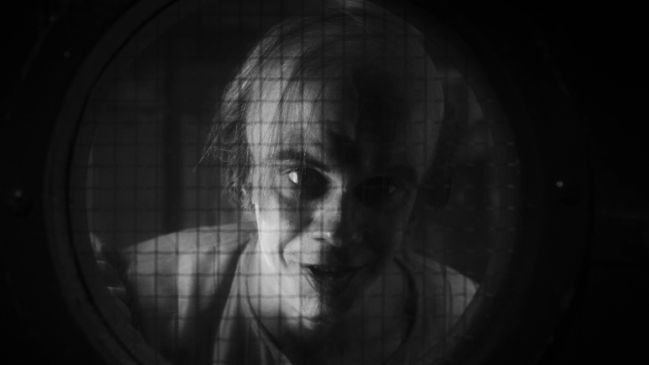 Pennywise as Bob Gray behind door window in IT: Welcome To Derry Episode 6