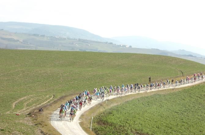 The peloton rides through the dirt roads of the Strade Bianche