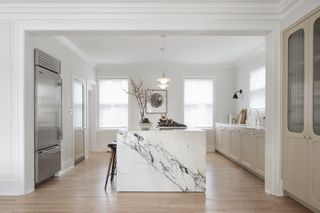 a neutral beige kitchen with a large marble island