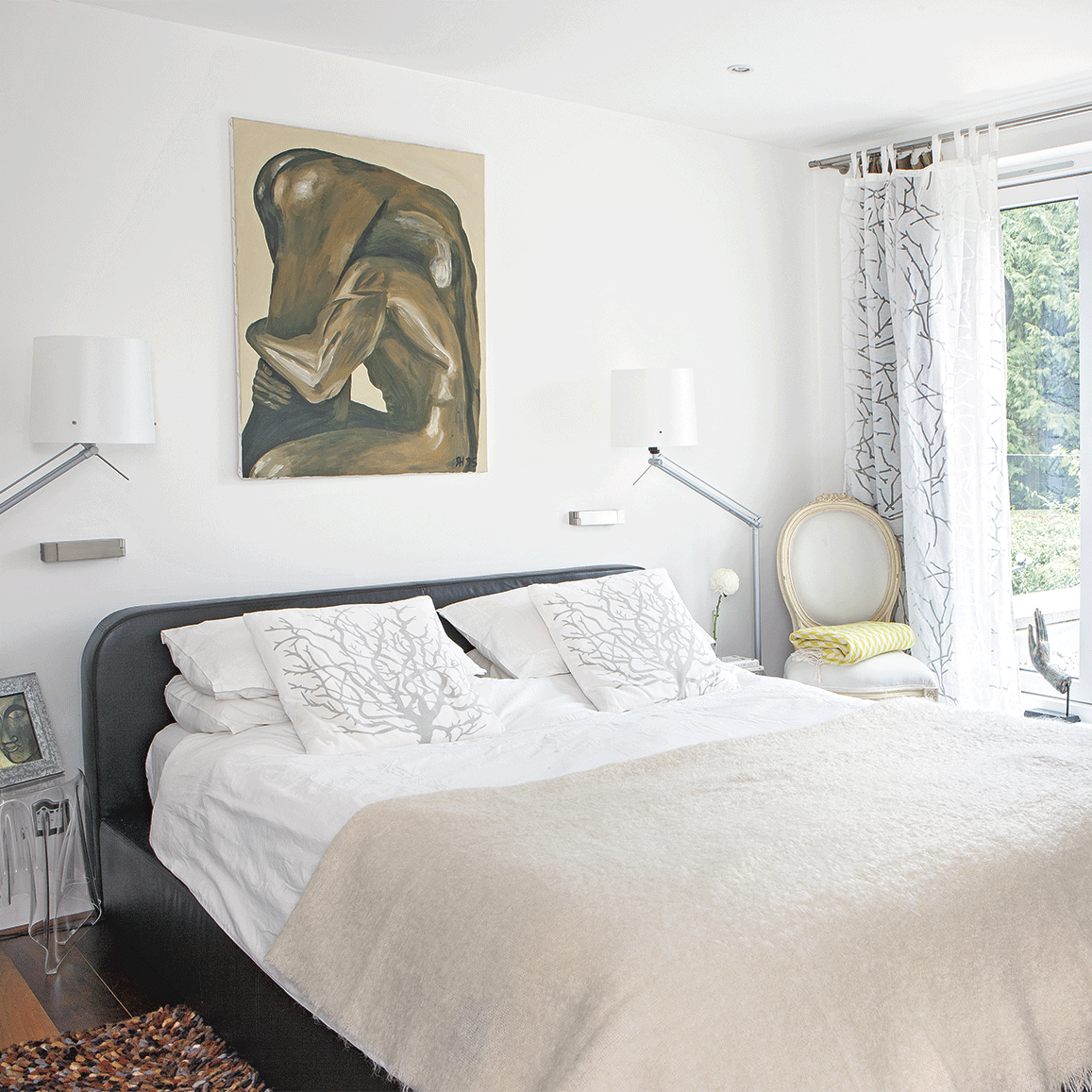 white bedroom with bedlinen textured rug and striking artwork
