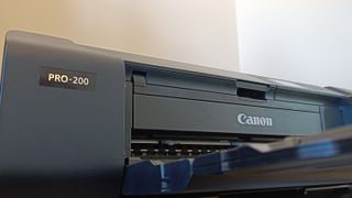 A black Canon Pixma Pro-200 printer sitting on a small table