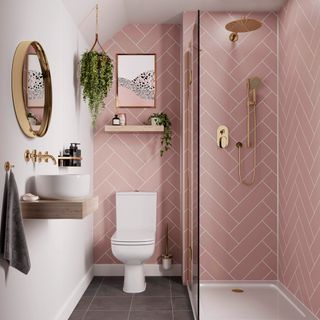 Small bathroom with dark grey floor tiles and pink subway tiles in a chevron pattern on the walls
