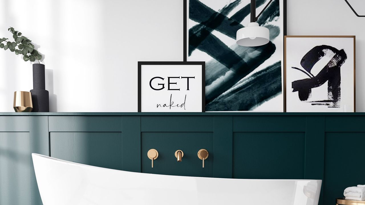 A dark green bathroom with abstract prints and white bathtub