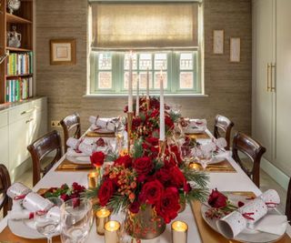 A red,white, and gold Christmas table with a floral centerpiece