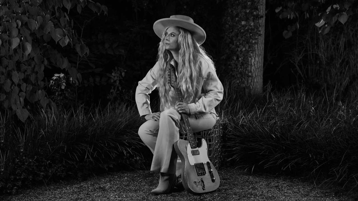 Joanne Shaw Taylor sitting in a garden holder a Fender Telecaster