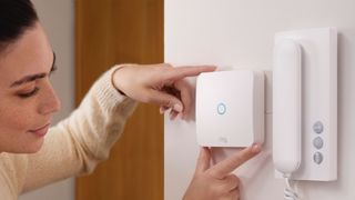 Ring Intercom on a wall, being used by a woman
