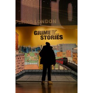 Photograph of silhouetted man in front of 'Grime Stories' mural at the Museum of London, by artist willkay