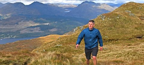 Hiker wearing Kathmandu Heli R Down Jacket at Ben Lomond