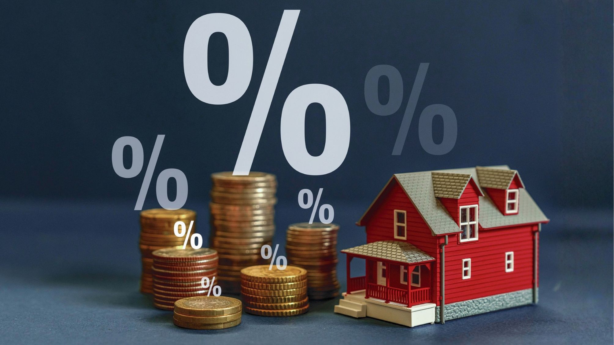 A model home next to a stack of gold coins with percent signs floating above.