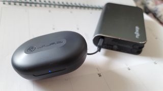 The JLab Go Air Sport's charging case being charged via portable charger