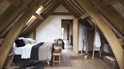 how to plan a loft conversion Bedroom in attic with wooden walls and double bed