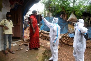 Health care workers doing door-to-door checkups, take a woman's temperature in Mumbai, India on July 2, 2020.