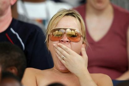 A woman yawns during a cricket match.