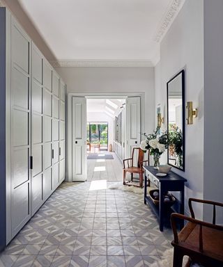 Hallway ideas with built-in storage cupboards and a tiled floor.