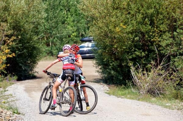 Overall first and second place women, Amanda Carey (Kenda) and Yolandi Du Toit (Squirt Lube) embrace after riding the stage together.