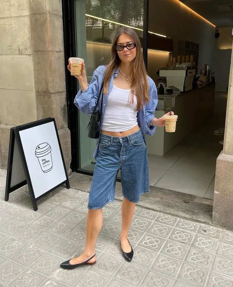Woman in jorts, white tank top, and flats.